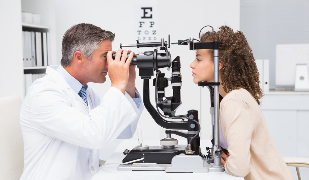 Optometrista, aki szemvizsgálatot végez, a lencse viselés kezdete előtt